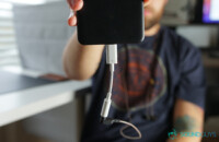 رجل يحمل هاتفًا مع Google Dongle بدلاً من سماعات الرأس USB-C.