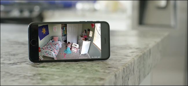جهاز iPhone يعرض تغذية Wyze Cam لطفل يلعب في غرفة نومها.
