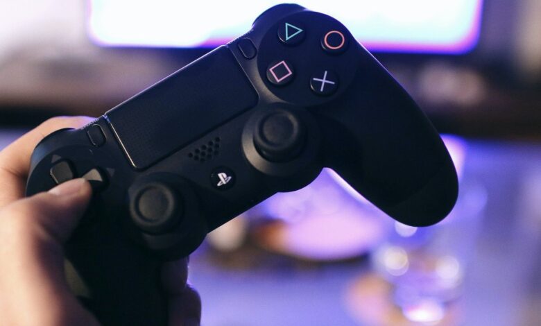 A PS4 controller being held by the D pad