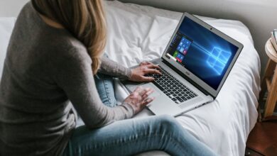 Woman using Windows 10 laptop on a bed
