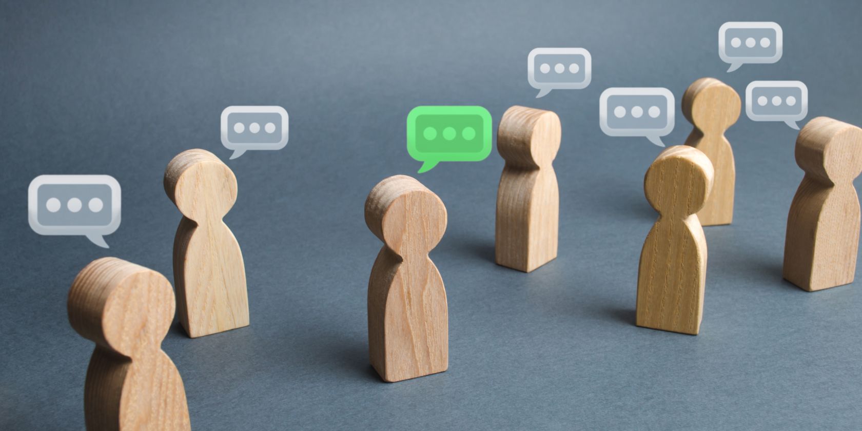 wooden people figures with speech bubbles overhead