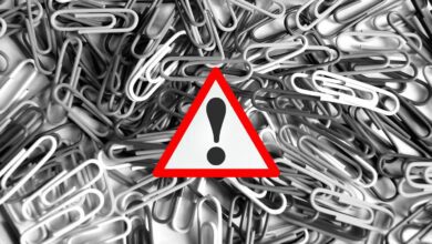 pile of paperclips behind alert symbol