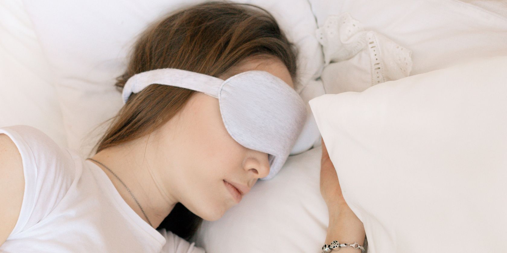 A woman sleeping with a white eye mask on